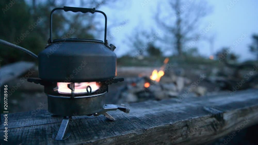 A kettle is heated on the gas burner at the campsite A kettle is heated on the gas burner at the campsite