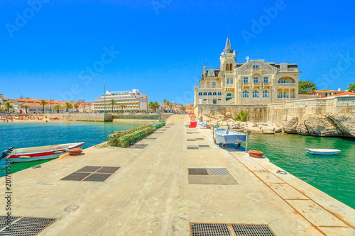 Seafront promenade with iconic Palace Seixas an old and abandoned building, and Praia da Ribeira beach or Praia dos Pescadores on seafront of Cascais, Lisbon Coast in Portugal from pier of Cascais.