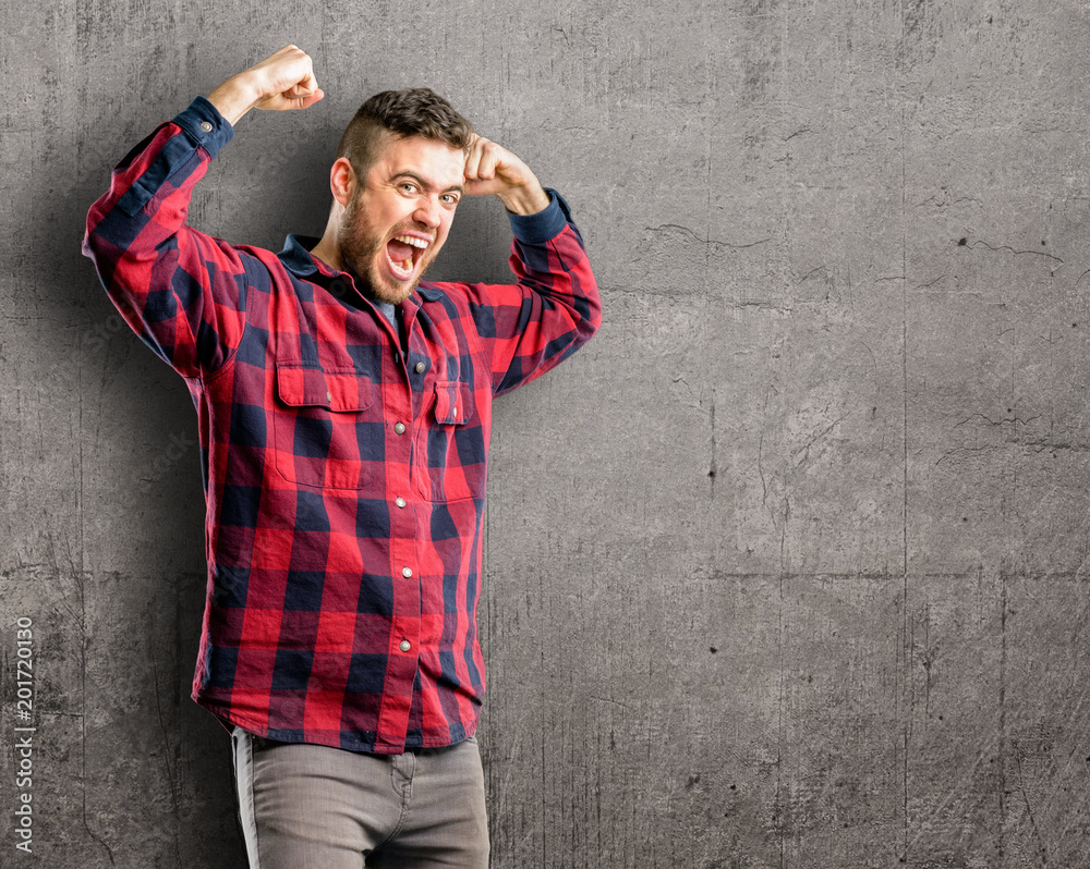 Young handsome man happy and excited celebrating victory expressing big success, power, energy and positive emotions. Celebrates new job joyful Young handsome man happy and excited celebrating victory expressing big success, power, energy and positive emotions. Celebrates new job joyful