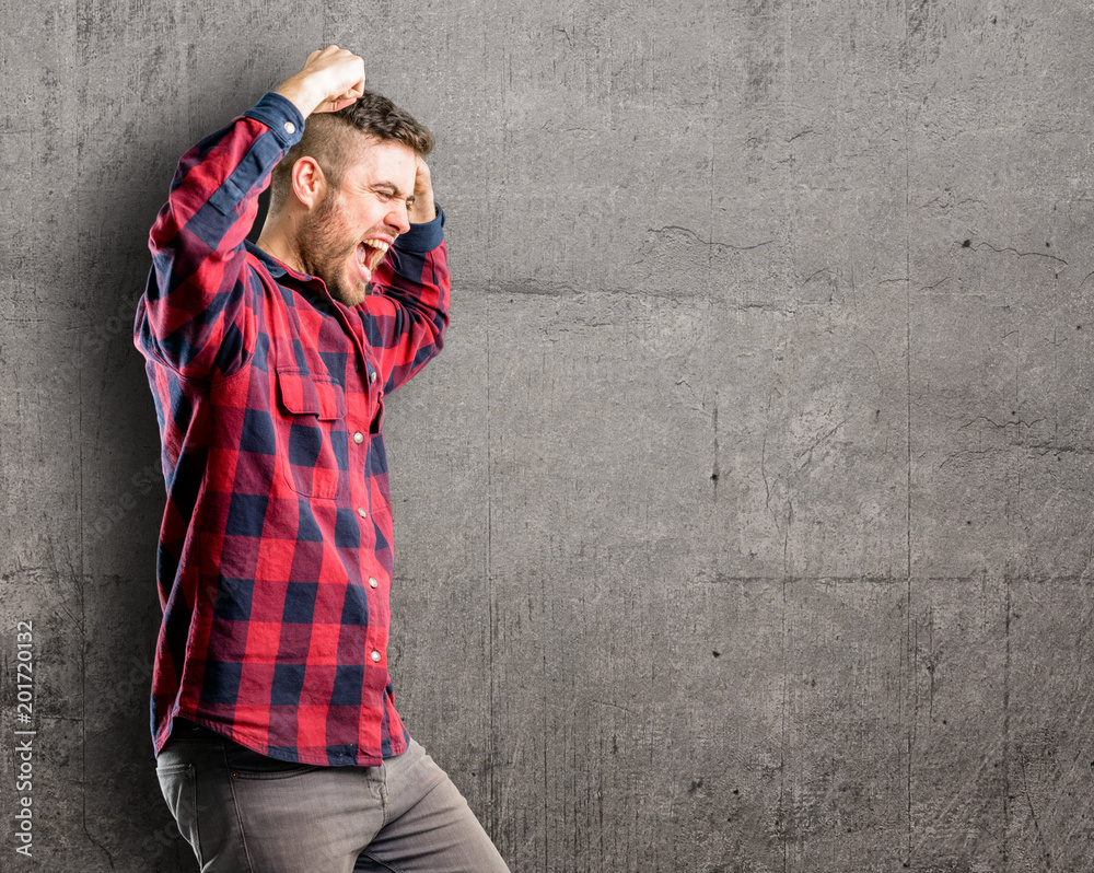 Young handsome man happy and excited celebrating victory expressing big success, power, energy and positive emotions. Celebrates new job joyful Young handsome man happy and excited celebrating victory expressing big success, power, energy and positive emotions. Celebrates new job joyful