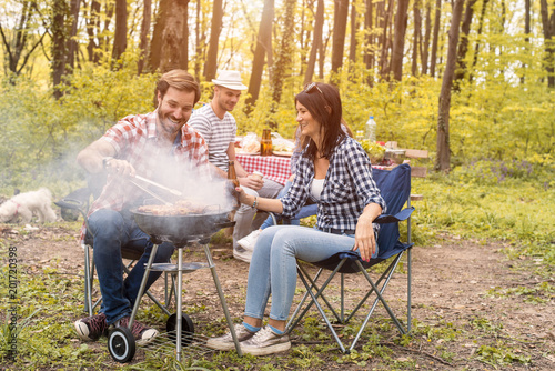 Two couples making barbecue and having fun outdoor