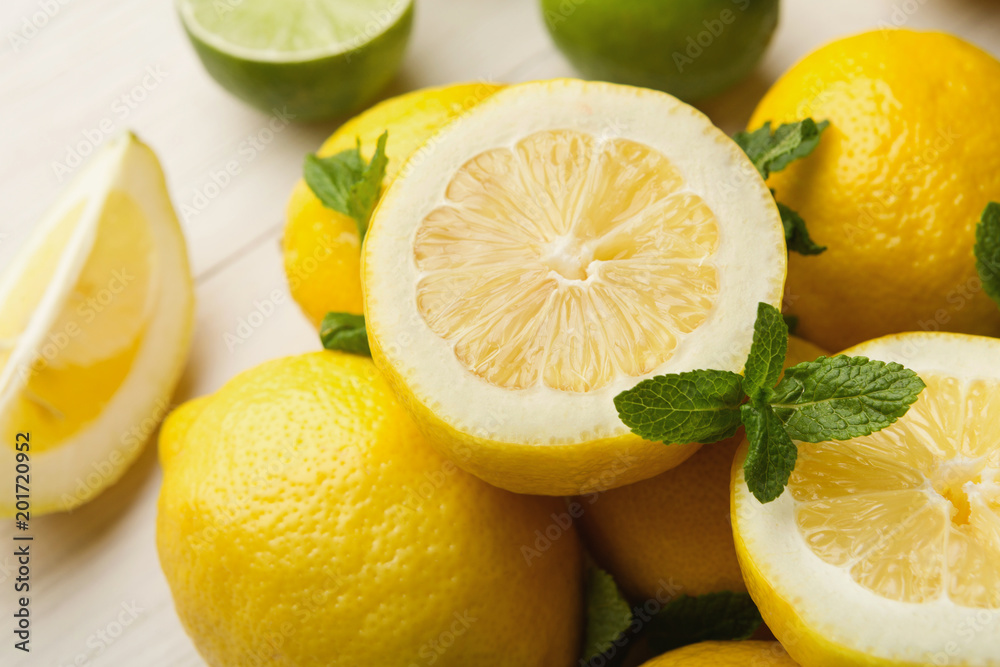 Heap of limes and lemons on white wood Heap of limes and lemons on white wood