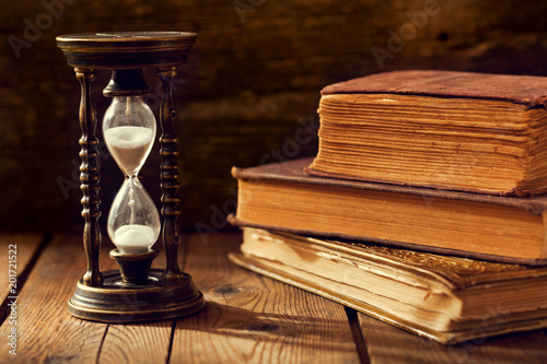 old hourglass with books