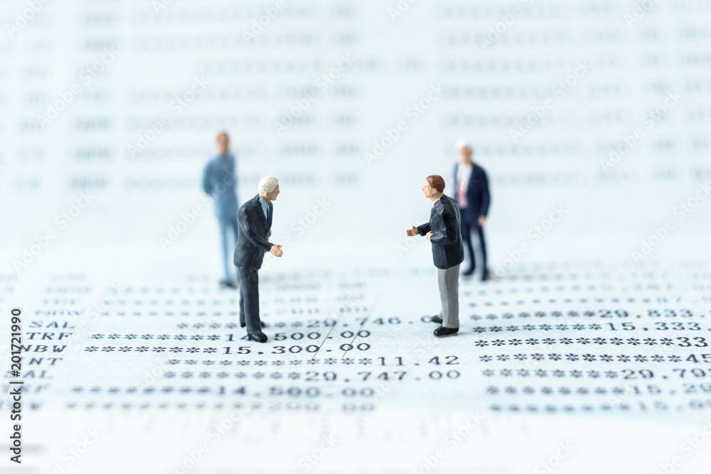 businessman miniature standing around for a meeting on a bank book businessman miniature standing around for a meeting on a bank book