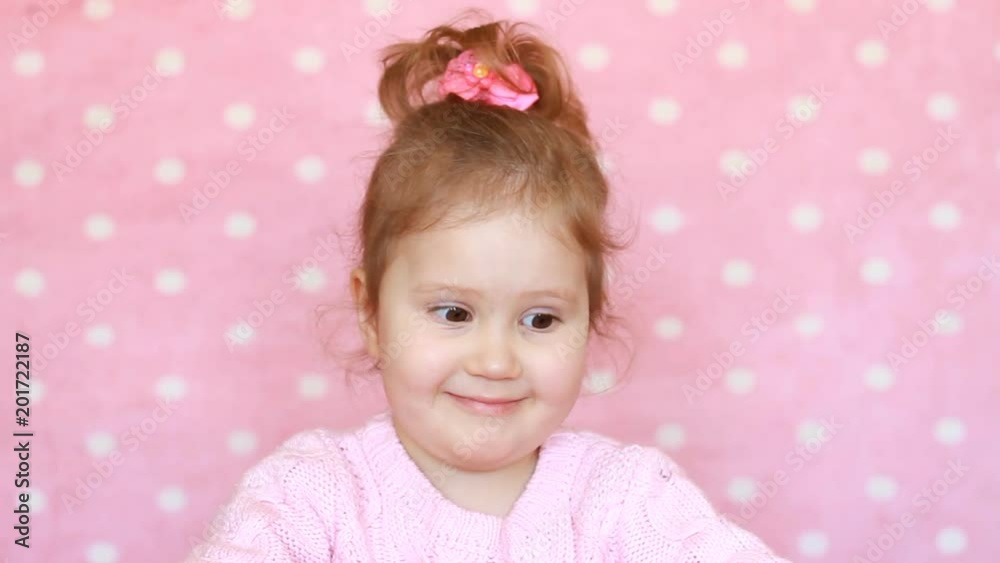 Allergy to pollen of flowers. A happy child smells the scent of a mimosa flower and sneezes. Portrait of a cute little girl on a pink background. Allergy to pollen of flowers. A happy child smells the scent of a mimosa flower and sneezes. Portrait of a cute little girl on a pink background.
