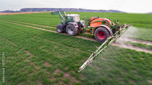 Obraz na plátně Traktor mit Anhängespritze beim UInkraut spritzen, Luftaufnahme - tilt shift Eff
