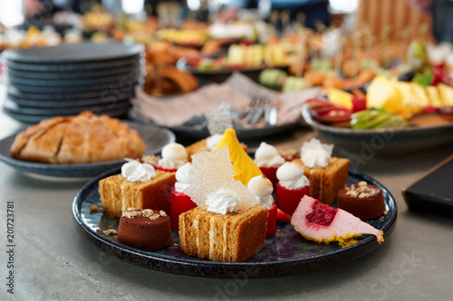 Desserts, fruits and other food on banquet table photo