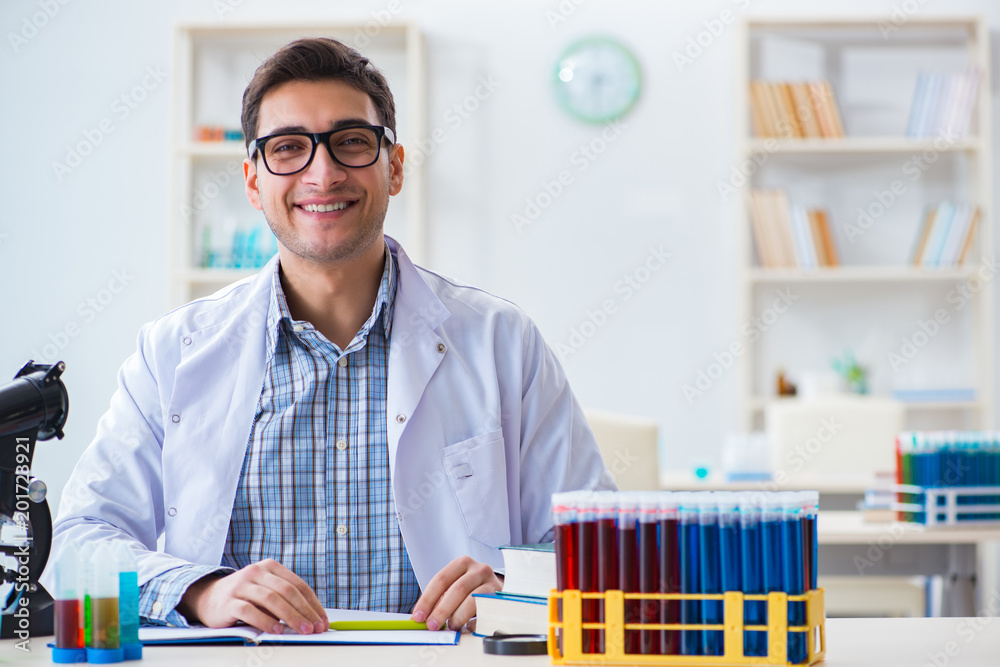 Young chemist student working in lab on chemicals