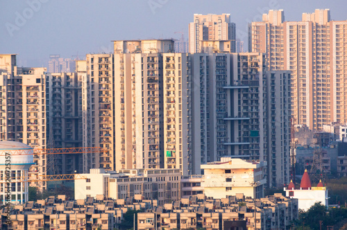 Cityscape with skyscrapers smaller apartment, water tower temple and other items. Typical in an indian city like noida gurgaon delhi hyderabad, chennai, bangalore etc
