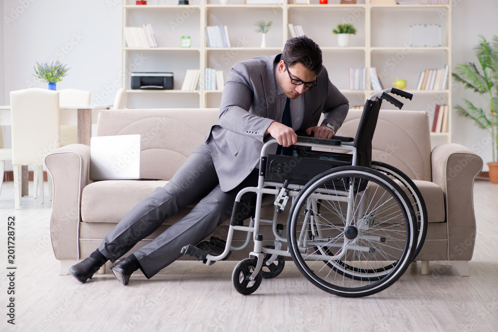 Dsabled businessman on wheelchair working home Dsabled businessman on wheelchair working home