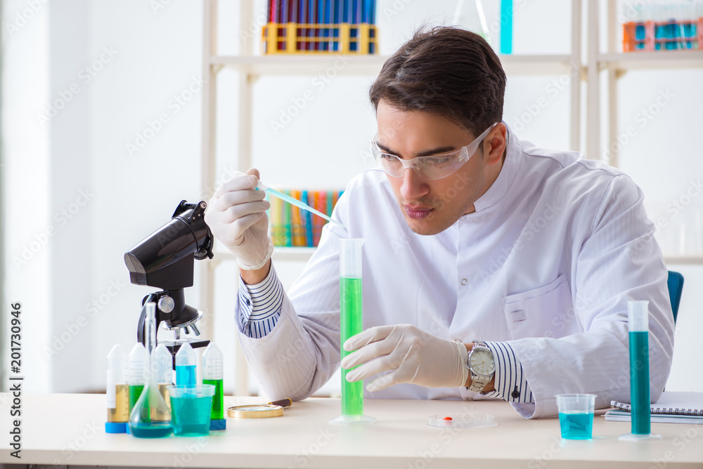 Young chemist student working in lab on chemicals Young chemist student working in lab on chemicals