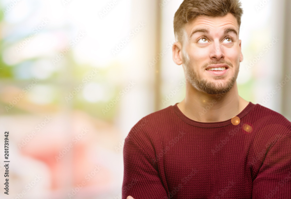 Handsome young man confident and happy with a big natural smile laughing looking up Handsome young man confident and happy with a big natural smile laughing looking up