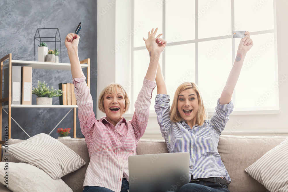 Happy adult woman and daughter using laptop at home Happy adult woman and daughter using laptop at home