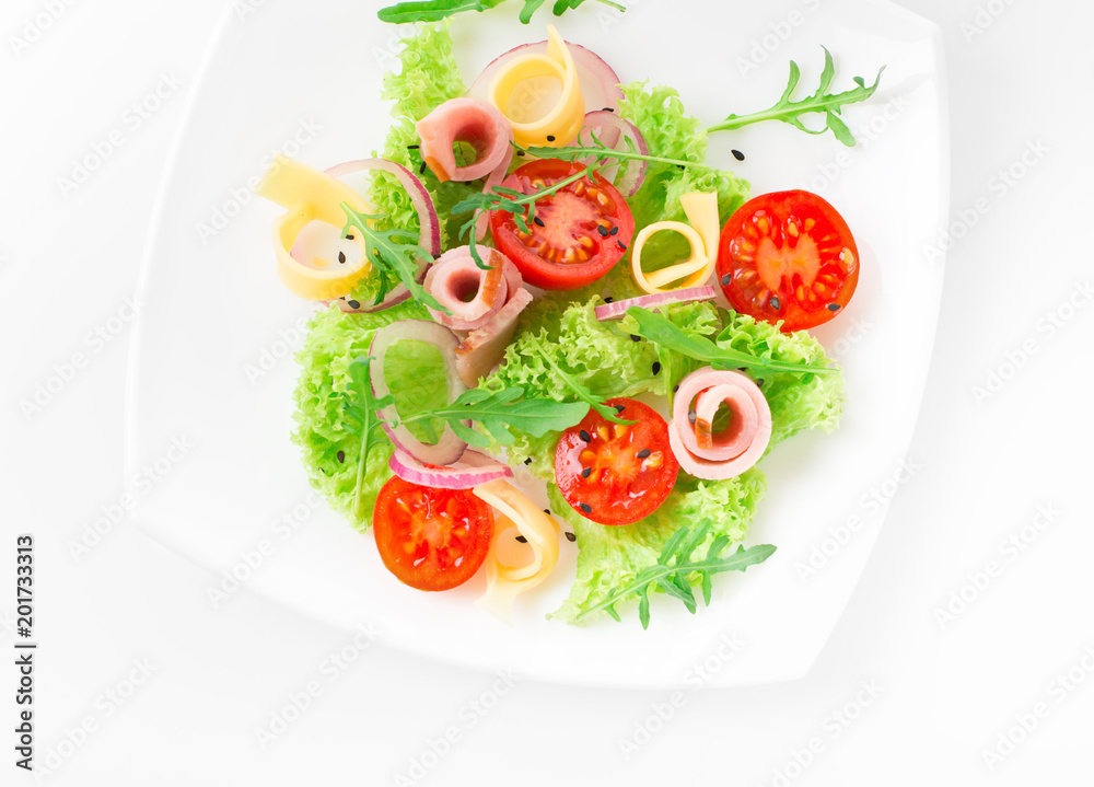 Fresh salad with tomatoes, arugula, cheese and ham on the white plate and white background