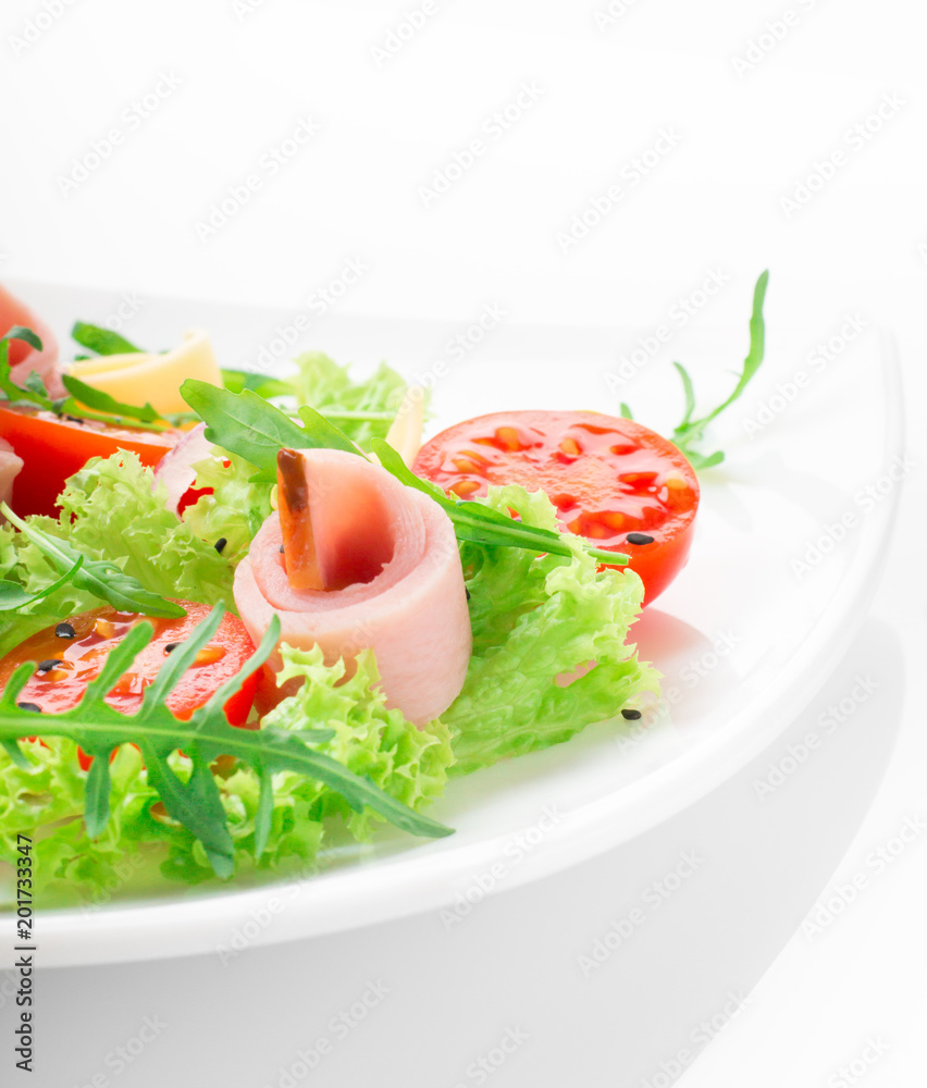 Fresh salad with tomatoes, arugula, cheese and ham on the white plate and white background Fresh salad with tomatoes, arugula, cheese and ham on the white plate and white background