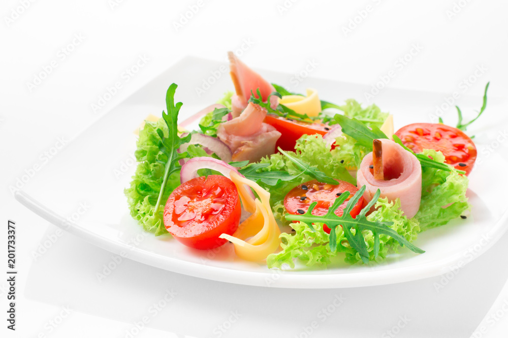 Fresh salad with tomatoes, arugula, cheese and ham on the white plate and white background