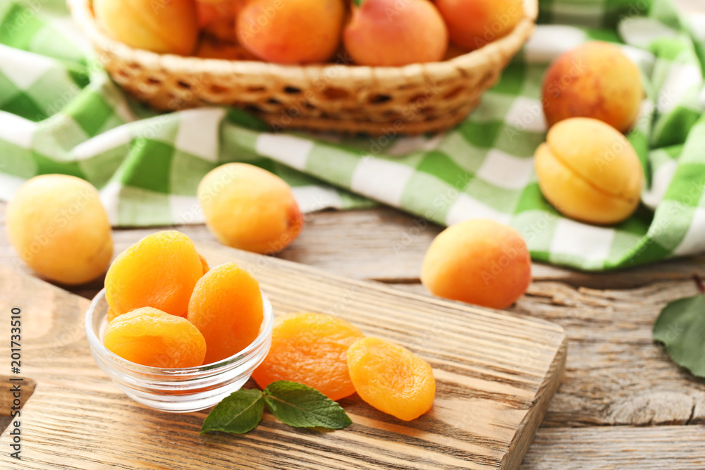 Sweet apricots in bowl on grey wooden table