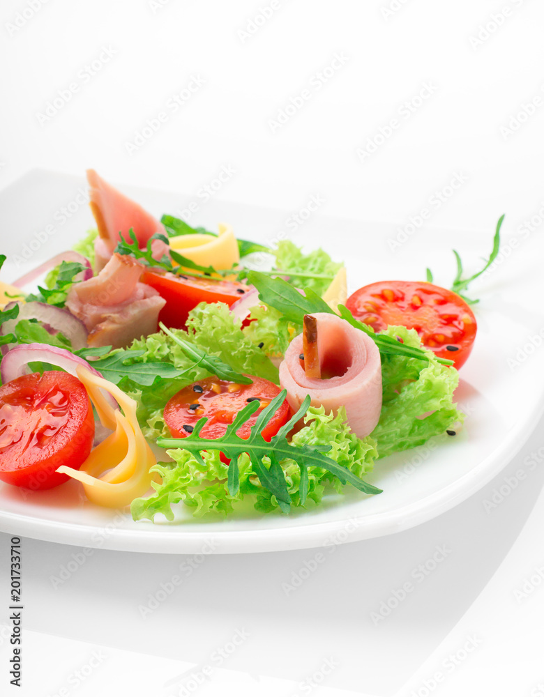 Fresh salad with tomatoes, arugula, cheese and ham on the white plate and white background