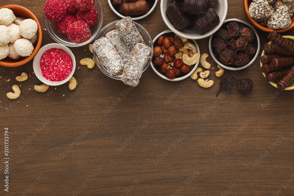 Wooden desktop with assortment of healthy sweets and nuts Wooden desktop with assortment of healthy sweets and nuts