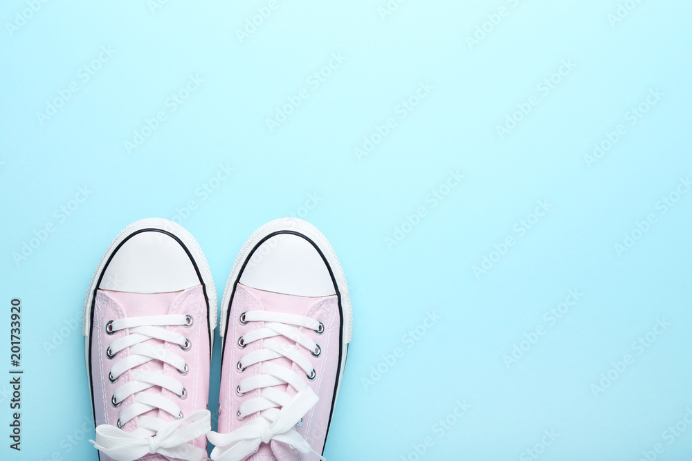 Pair of pink sneakers on blue background