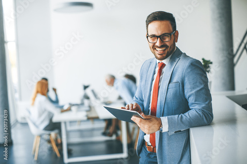 Young businessman with digital tablet in office photo