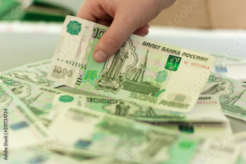 money, Russian thousand bills on the table, children's hand takes the bill in hand