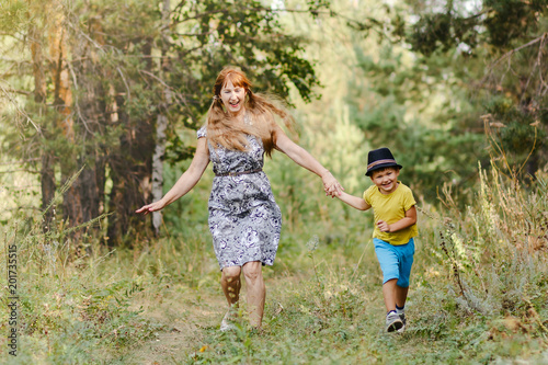 young grandmother with grandson running in the Park in the summer