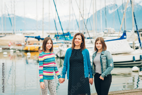 Outdoor portrait of happy mother and two young teenage girls © annanahabed