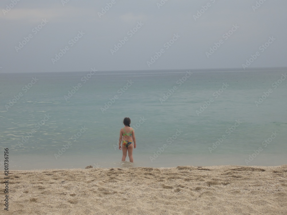 Little girl is playing on the beach alone Little girl is playing on the beach alone