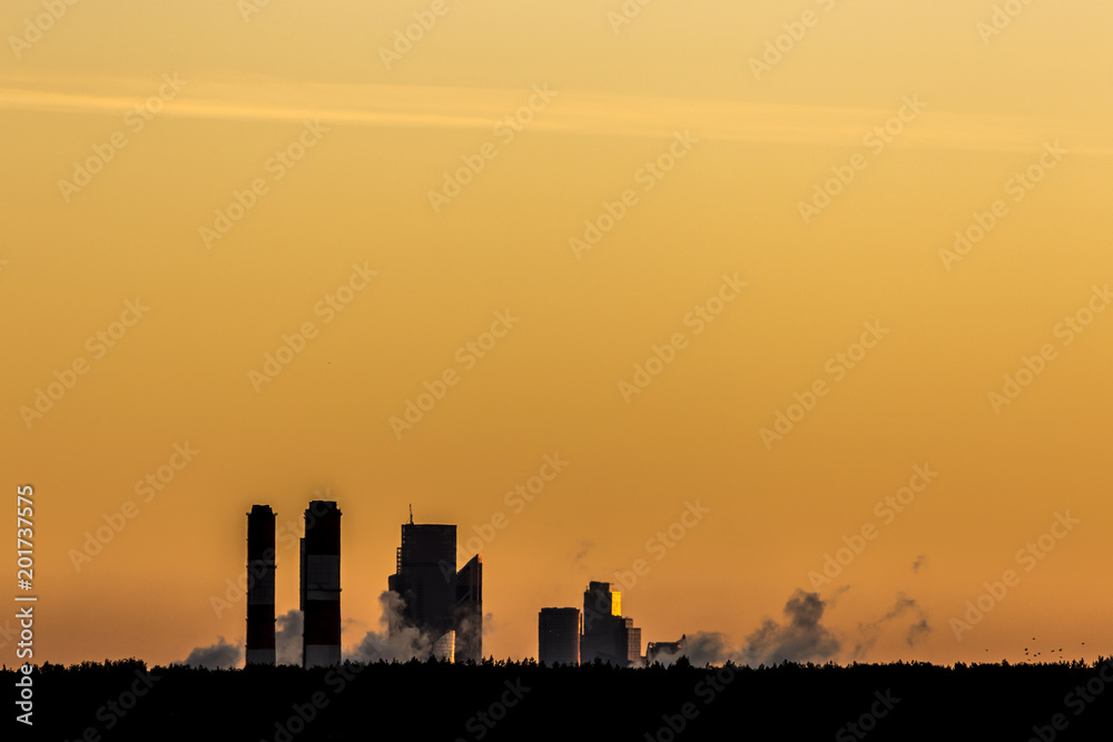 Big industrial pipes at sunset, air pollution in city environment
