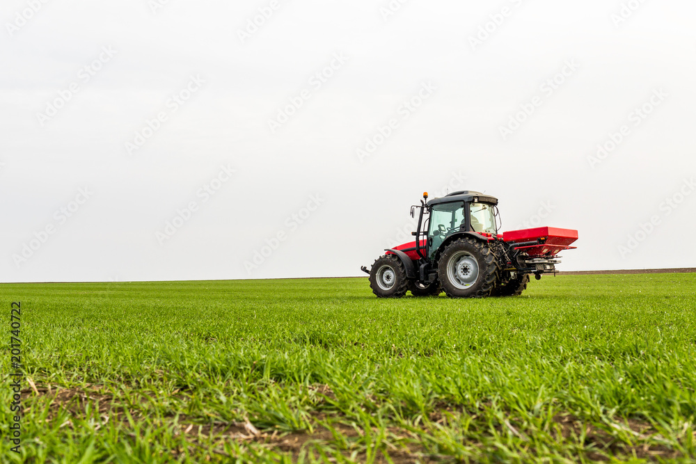 Farmer in tractor fertilizing wheat field at spring with npk Farmer in tractor fertilizing wheat field at spring with npk