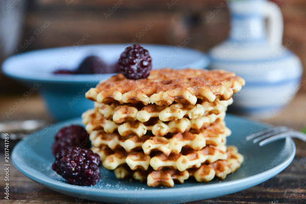 Round waffles with fresh blackberries and icing sugar on wooden background rustic Round waffles with fresh blackberries and icing sugar on wooden background rustic