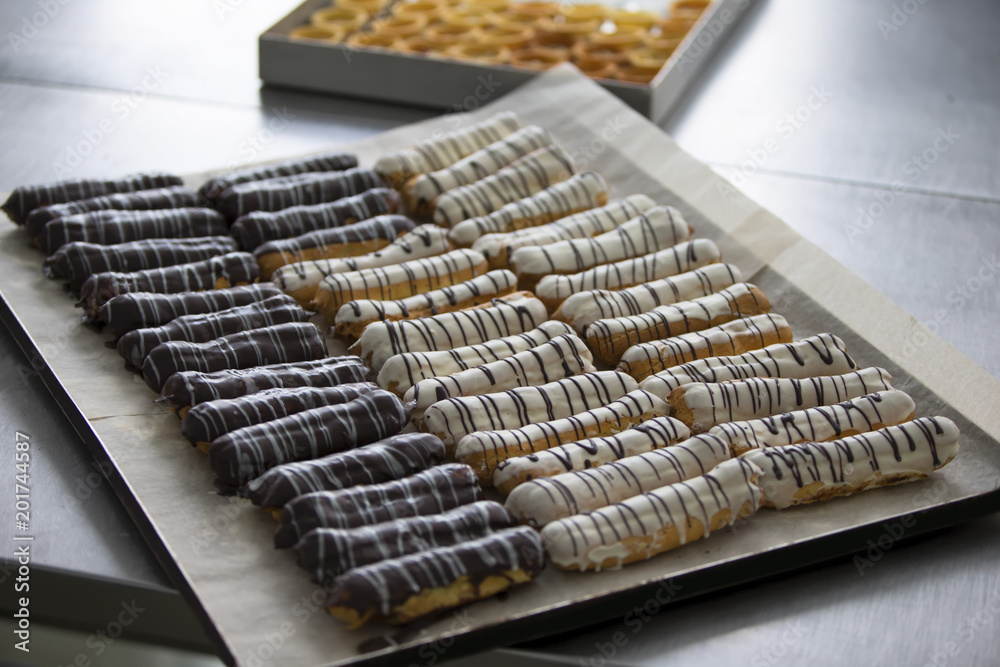A lot of eclairs on the coated with icing coating A lot of eclairs on the coated with icing coating