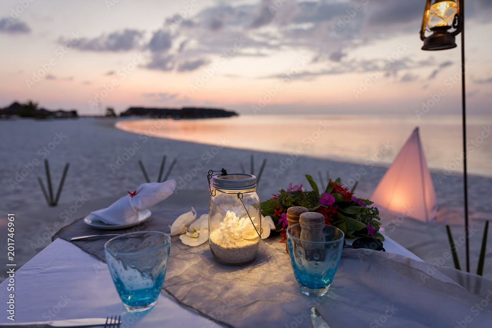 Romantisch gedeckter Tisch am tropischen Strand bei Sonnenuntergang Stock  Photo | Adobe Stock