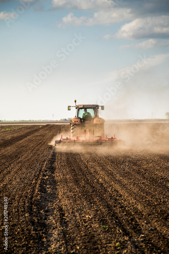 Tractor cultivating field at spring © oticki