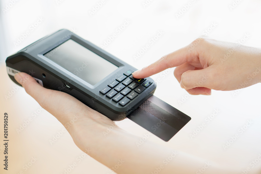 Hand with credit card swipe through terminal Hand with credit card swipe through terminal