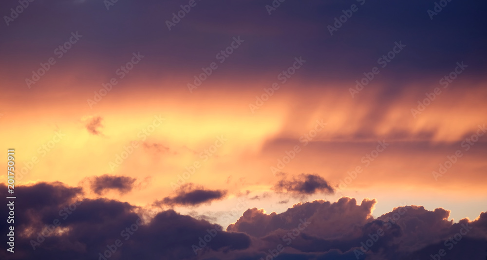Landscape woth beautiful purple sunset with colorful surreal dark clouds on fiery sky in the evening panoramic view