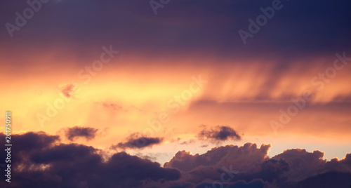 Landscape woth beautiful purple sunset with colorful surreal dark clouds on fiery sky in the evening panoramic view
