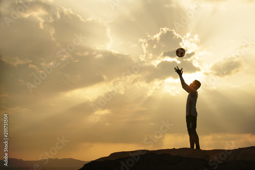 silhouette man throw ball with sunrise or sunset background