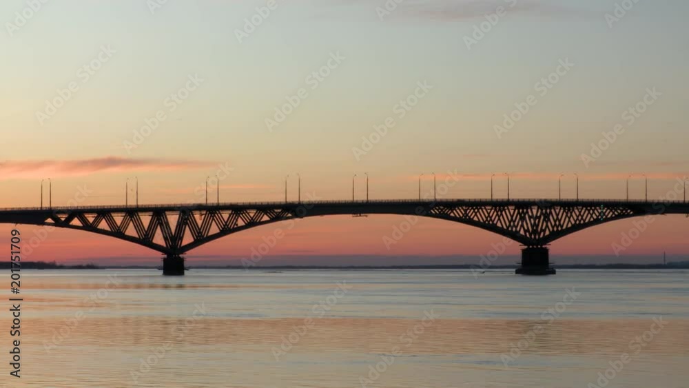 Time lapse. Dawn on the Volga river. Road bridge between the cities of Saratov and Engels, Russia. Early April morning.