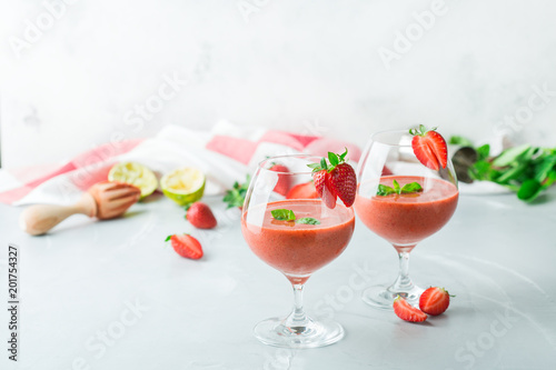 Alcohol cocktail with vodka, strawberry, lime, basil and ice