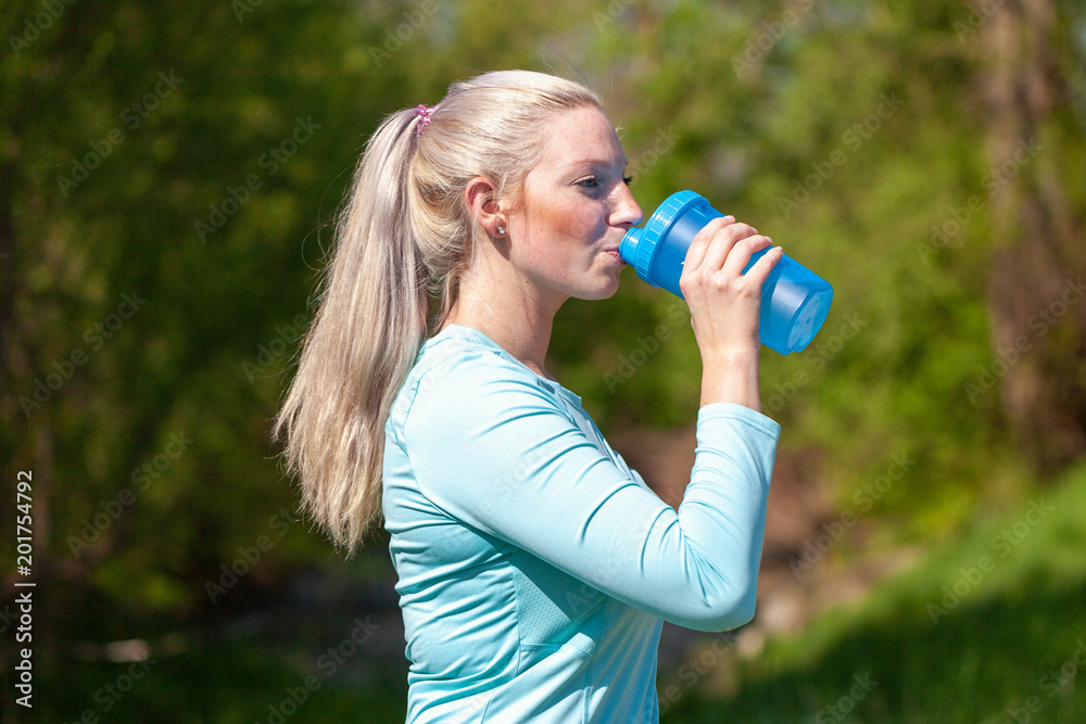 Young woman drinks water in a sport dress Young woman drinks water in a sport dress