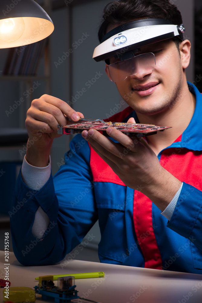 Computer specialist repairing PC late at night Computer specialist repairing PC late at night