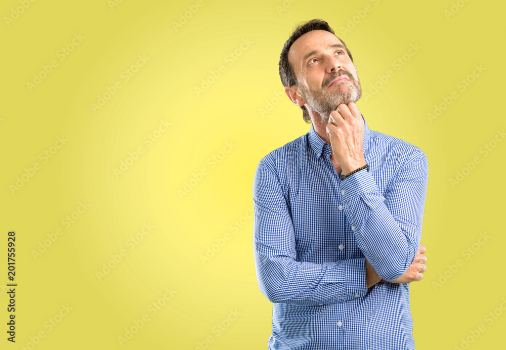 Handsome middle age man thinking and looking up expressing doubt and wonder Handsome middle age man thinking and looking up expressing doubt and wonder