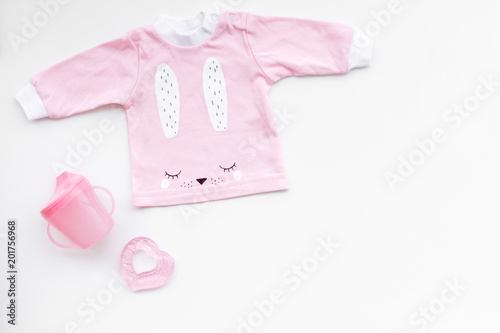 Child birth concept. Clothes and accessories for newborn on white background top view copy space