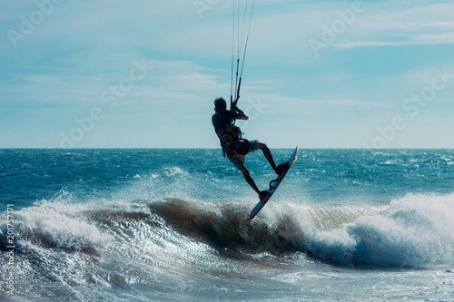 Kitesurfer jumping on a beautiful background of spray during the sunset