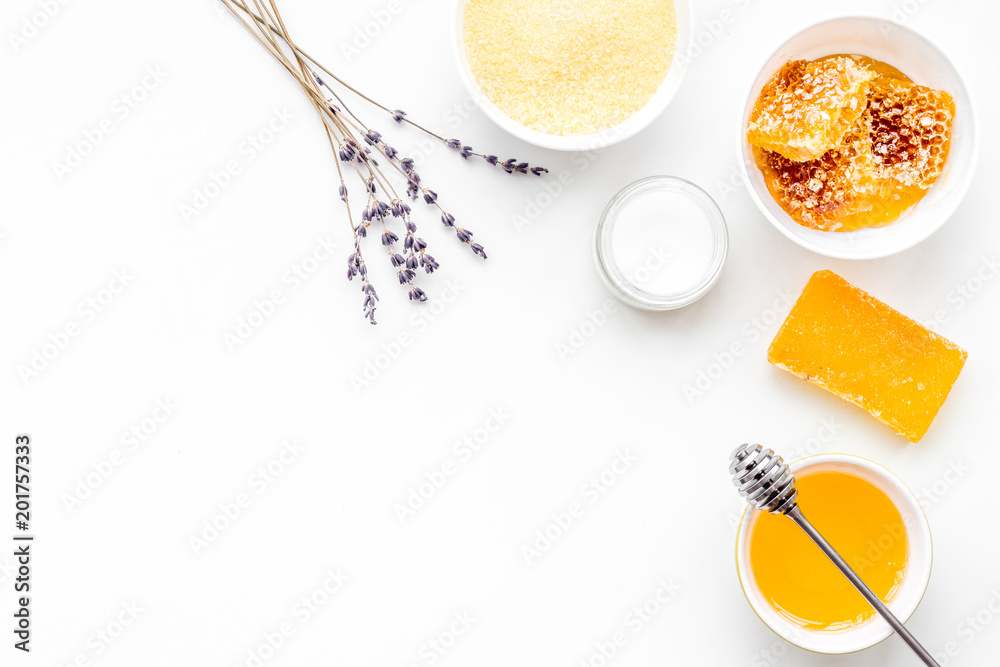 Homemade cosmetics with honey. Handmade soap, spa salt, cream on white background top view copy space Homemade cosmetics with honey. Handmade soap, spa salt, cream on white background top view copy space