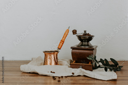 Turkish coffee pot and mill on linen napkin. Rural rustic background