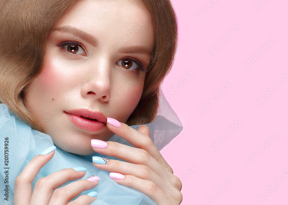 Beautiful girl with light make-up and gentle manicure in blue clothes. Beauty face. Design nails. Photo taken in studio on pink background Beautiful girl with light make-up and gentle manicure in blue clothes. Beauty face. Design nails. Photo taken in studio on pink background