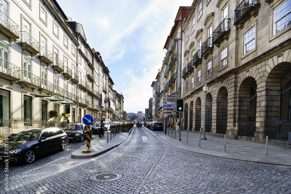 Porto, Portugal. August 12, 2017: Central street of the city wide and cobbled with cobblestones with facades of old stone houses and little traffic